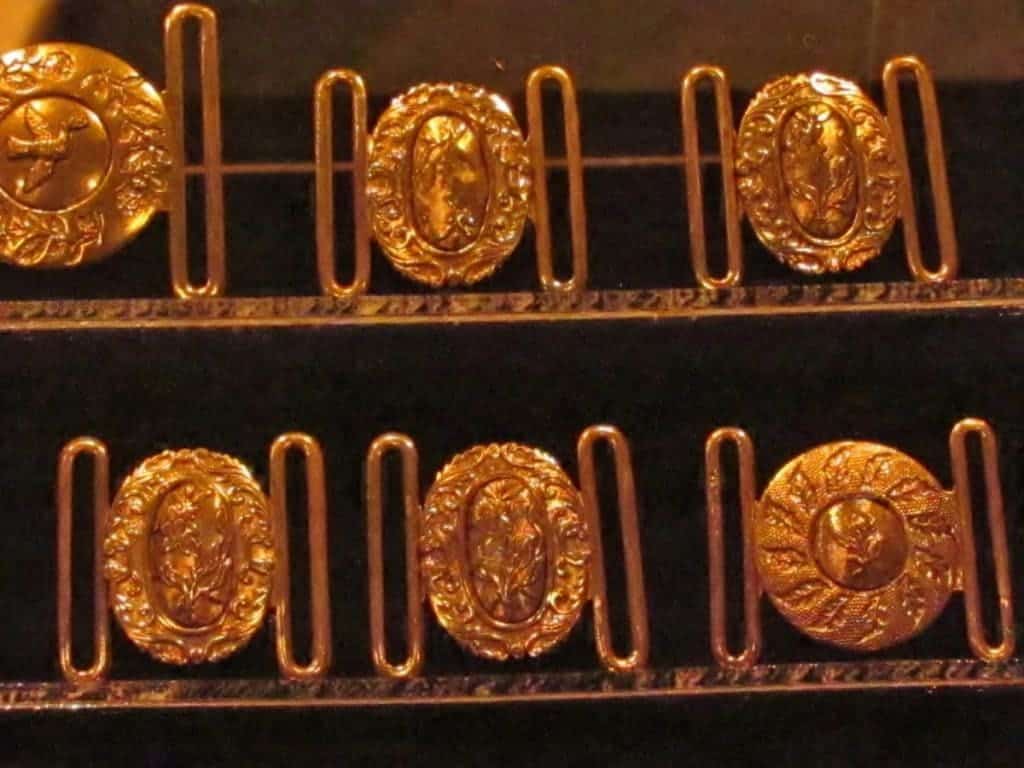 Golden buckles are displayed as part of the items recovered from the wreckage. 