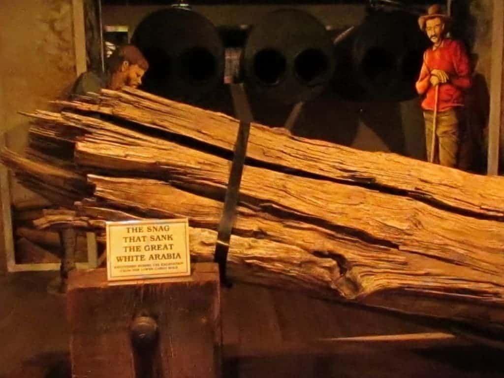 A large tree trunk is displayed as the object that caused the damage, which resulted in the sinking of the Arabia Steamboat.