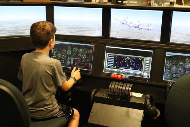A boy tests his skills on a flight simulator.