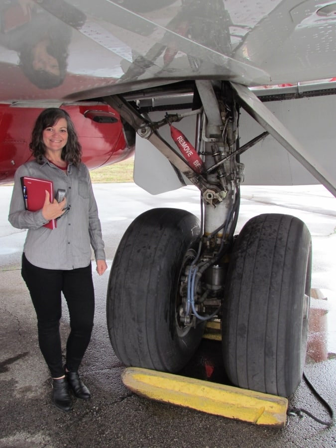The landing gear of an airplane compared to an avergae human's height.