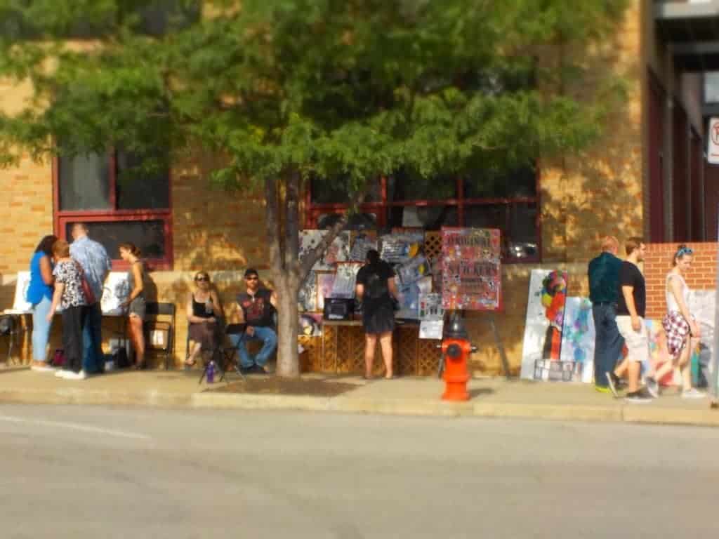 Local artists sell their art on the sidewalk.
