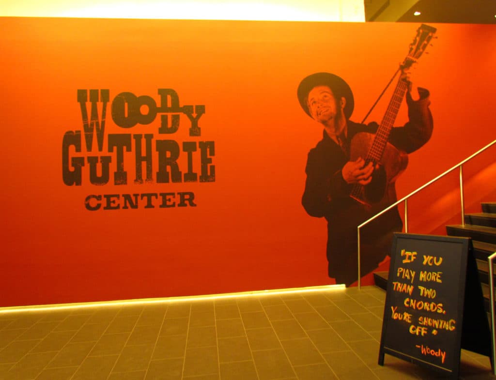 The entrance to the Woody Guthrie Center showcases a picture of the artist with his easily recognizable guitar.