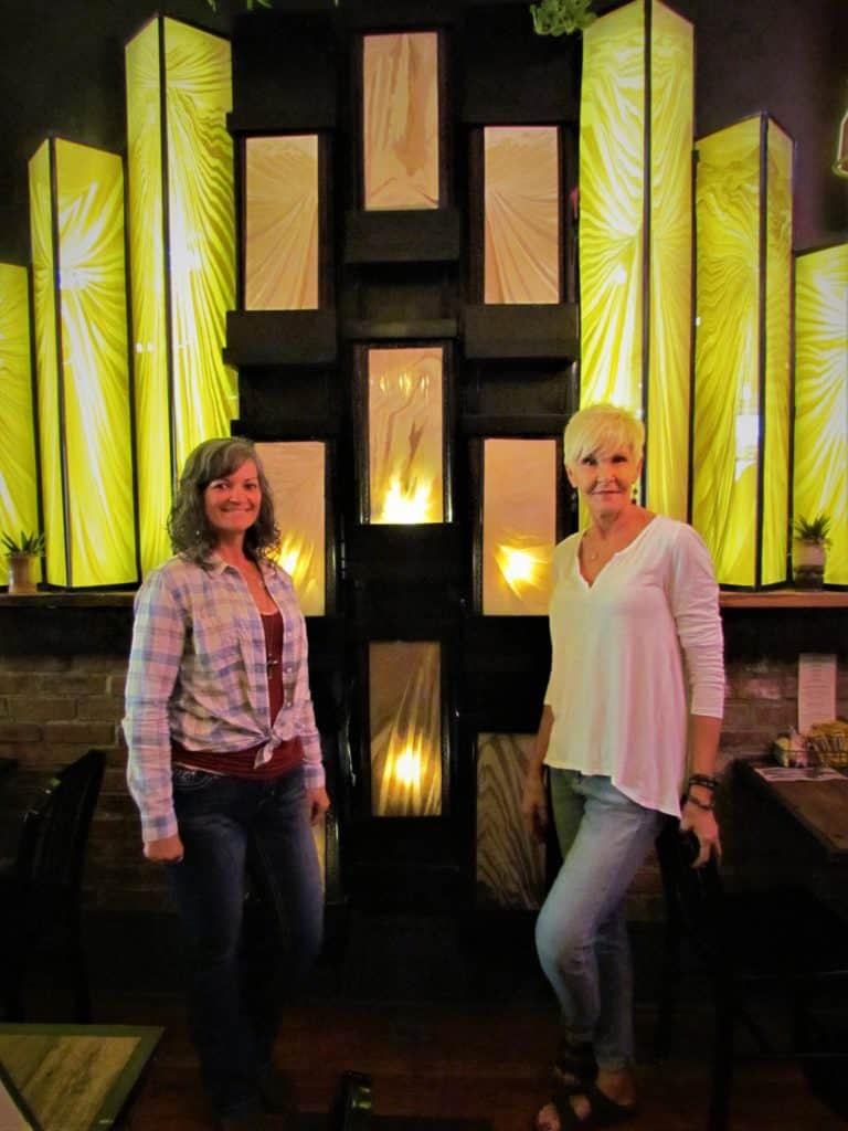 Crystal and Bobbie pose in front of a one-of-a-kind stained glass water feature. 