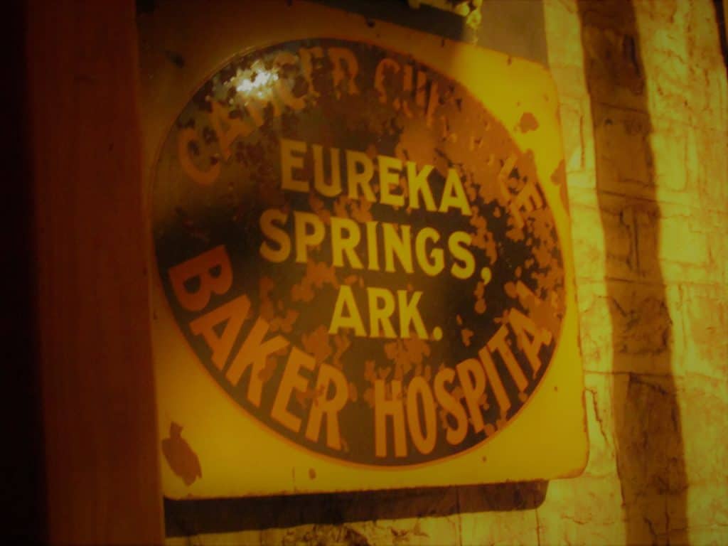 A fading signn from the Baker Cancer Hospital that once occupied the 1889 Crescent Hotel and Spa building.