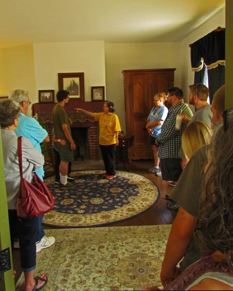 The tour guide points out interesting facts about the Grinters and their home in Wyandotte County.