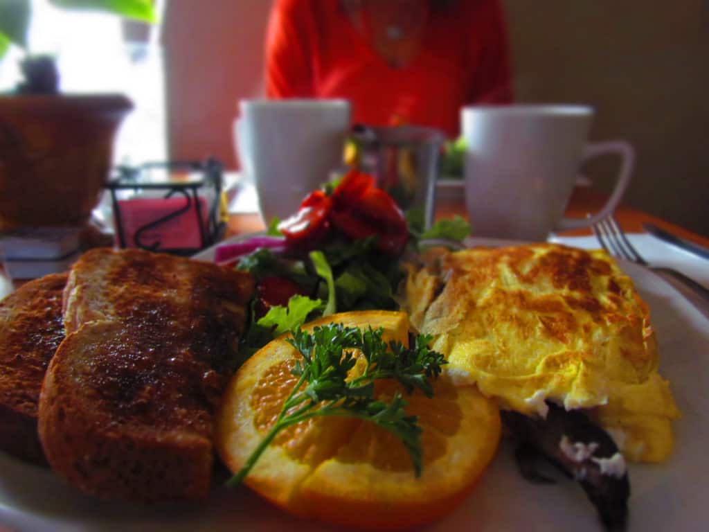 A mushroom and goat cheese omelet is the main course on a breakfast filled with salad and wheat berry toast. 