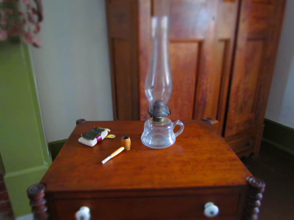 A pipe and tobacco rest on a table near the fireplace.