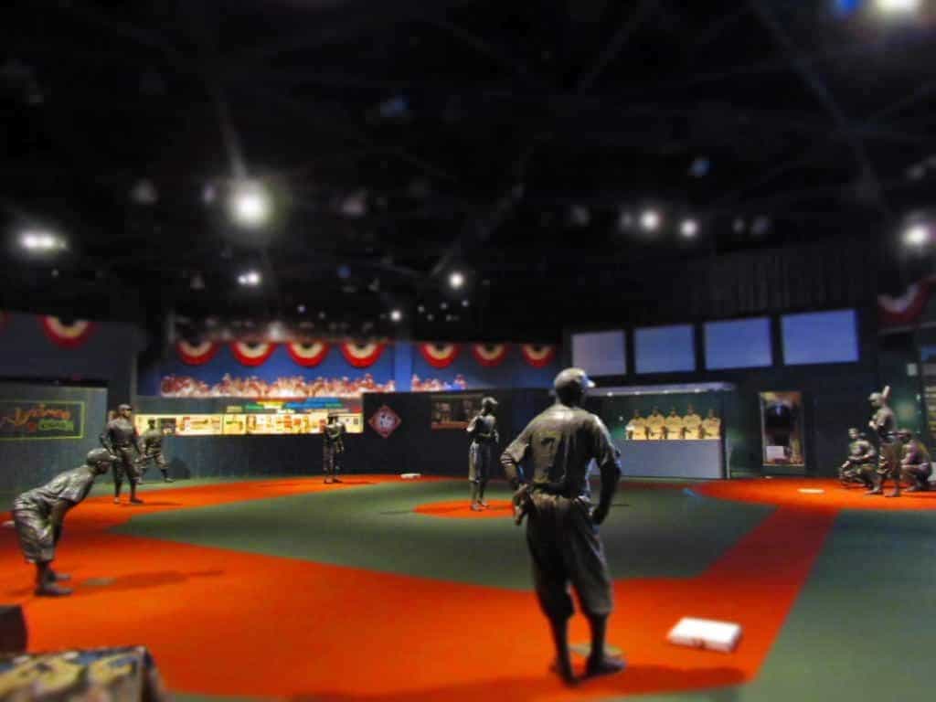 Visitors to the Negro Leagues Baseball Museum work their way through the exhibits until they reach the field of iconic players represented with life-size statues.