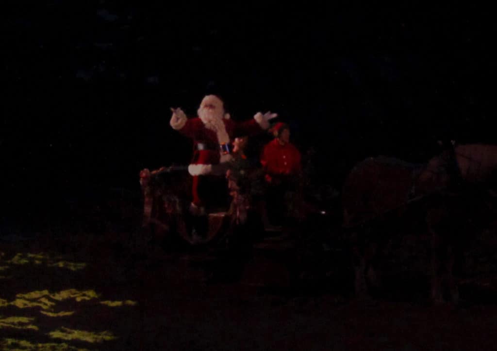 Santa arrives by sleigh to greet the crowd.