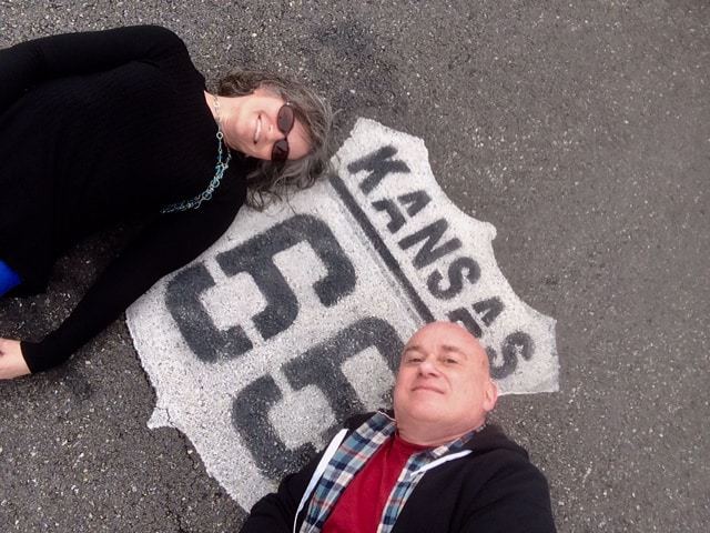 The authors pose for a selfie, while lying on part of Route 66.