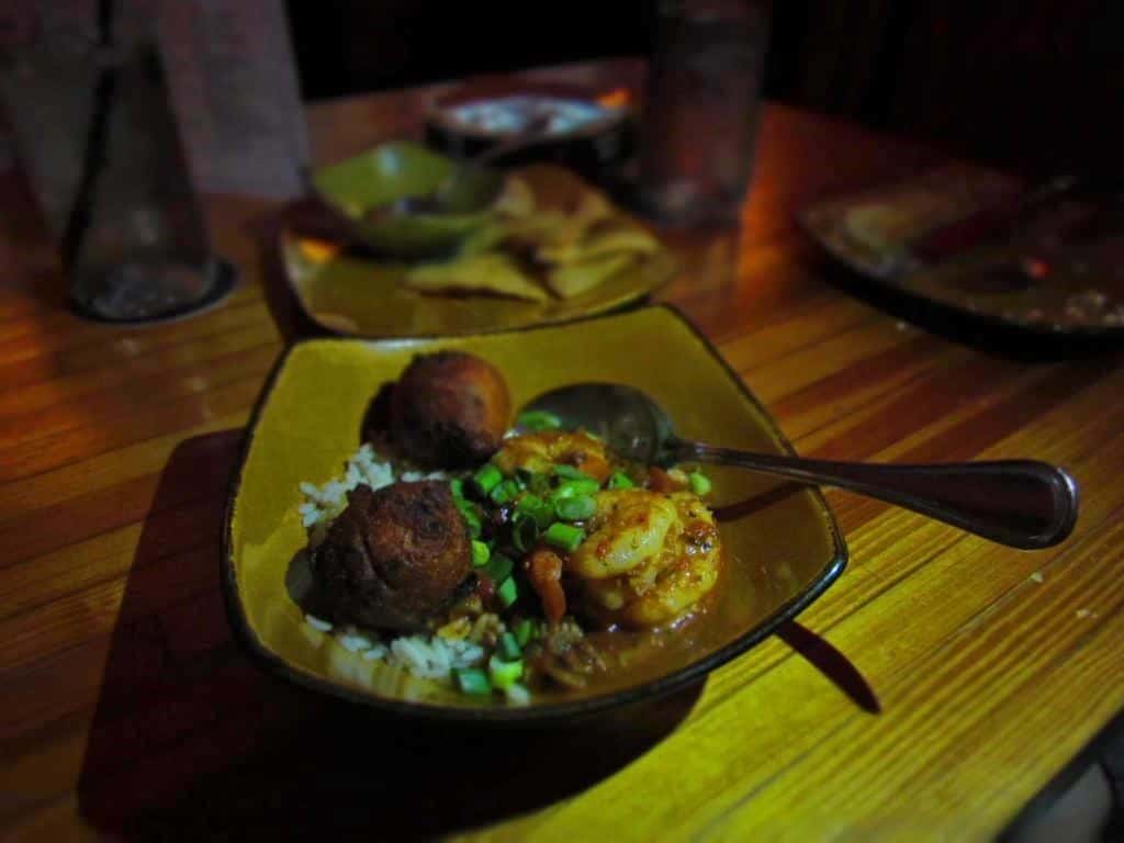 A bowl of shrimp etouffee is combined with spicy hushpuppies.