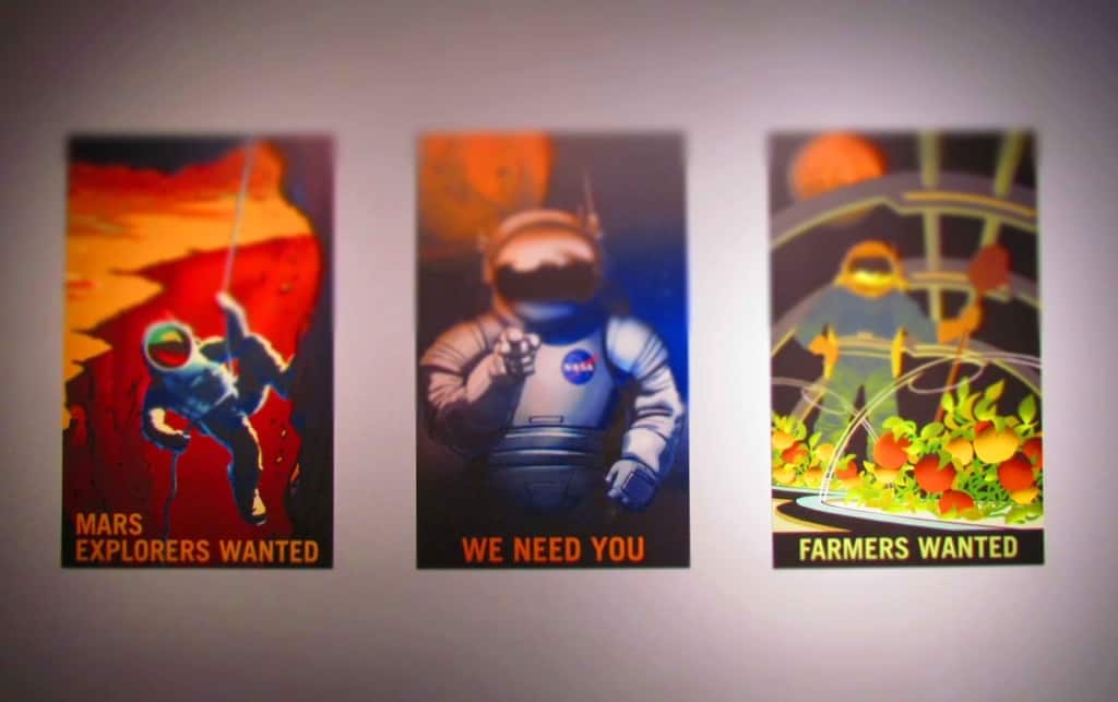 A series of mock posters advertise the need for participants to travel to Mars.