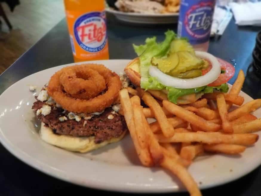 A Bacon and Bleu Burger comes topped with crispy onion rings. 
