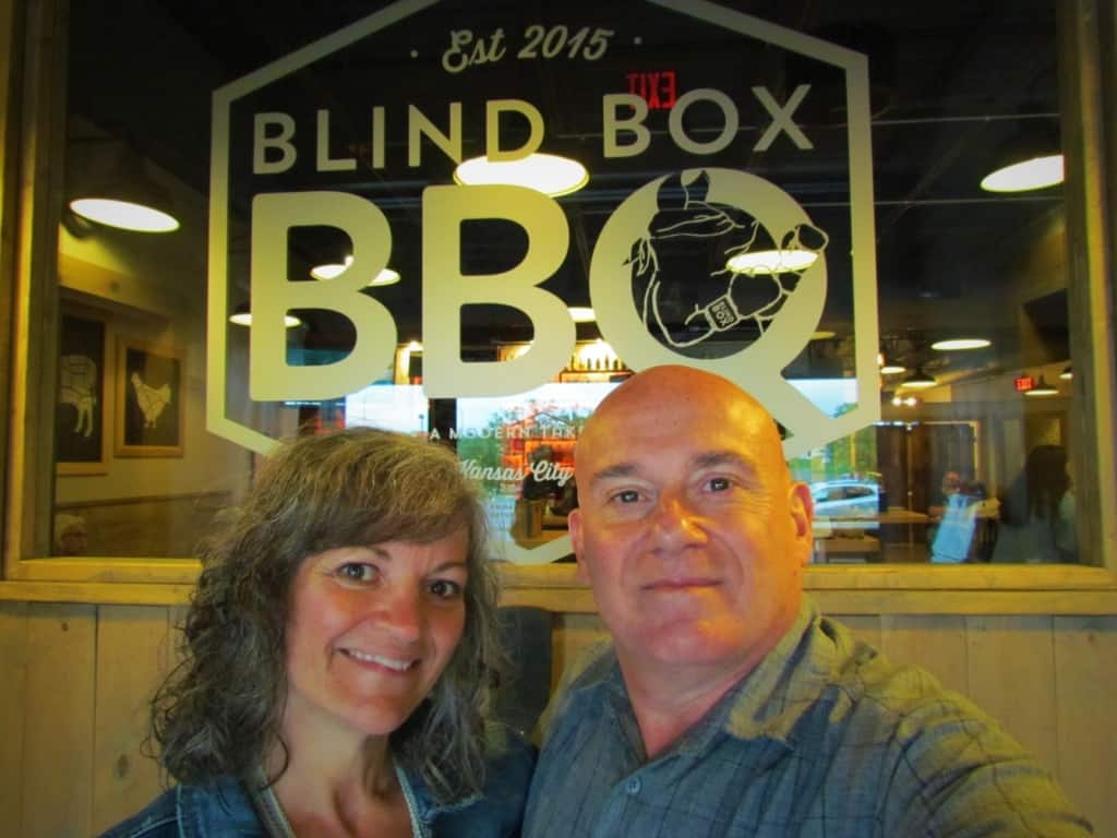 The authors pose for a selfie in front of the Blind Box BBQ logo.