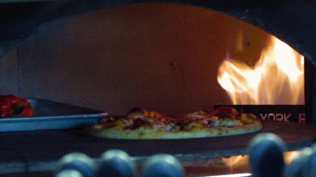 The wood fired oven cooks pizzas to perfection.