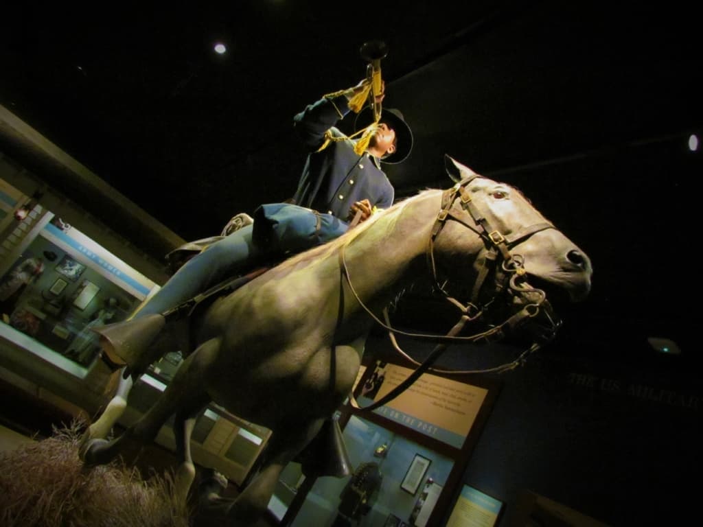 An Army soldier is poised on a horse in a recreation of a scene from the Wild West. 