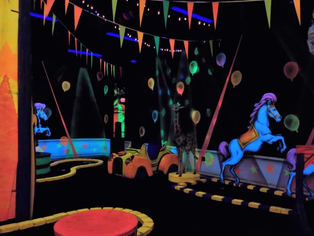 The use of black-lights helps add to the circus atmosphere at this indoor mini-golf course.