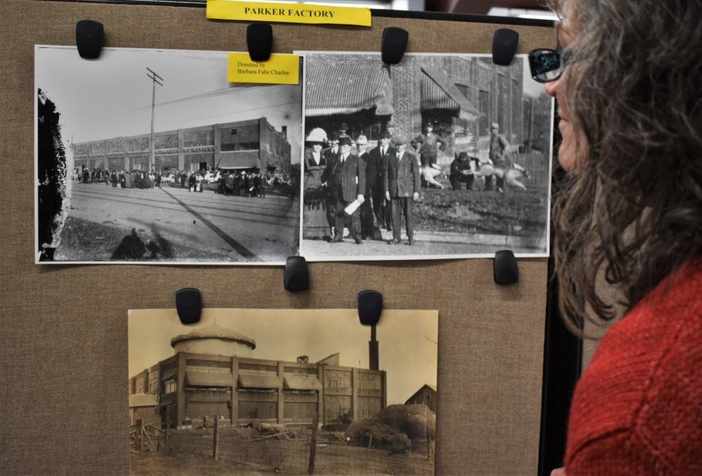 Crystal examines photos of the Parker factory in Leavenworth, Kansas. 