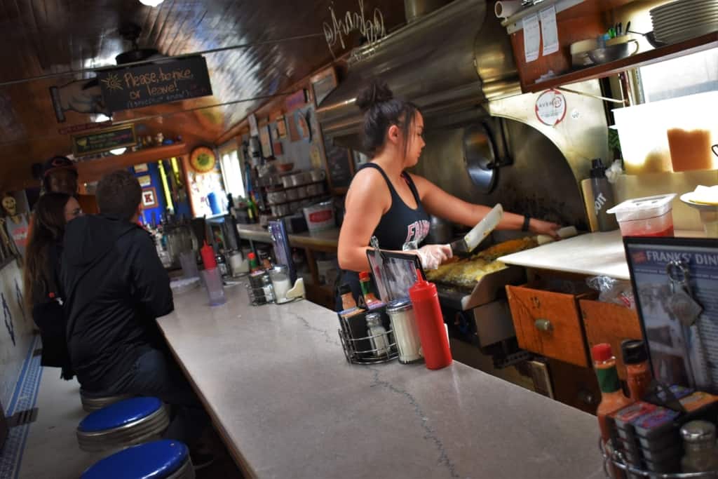 The fry cook loads the griddle with over-sized servings of food at Franks' Diner. 