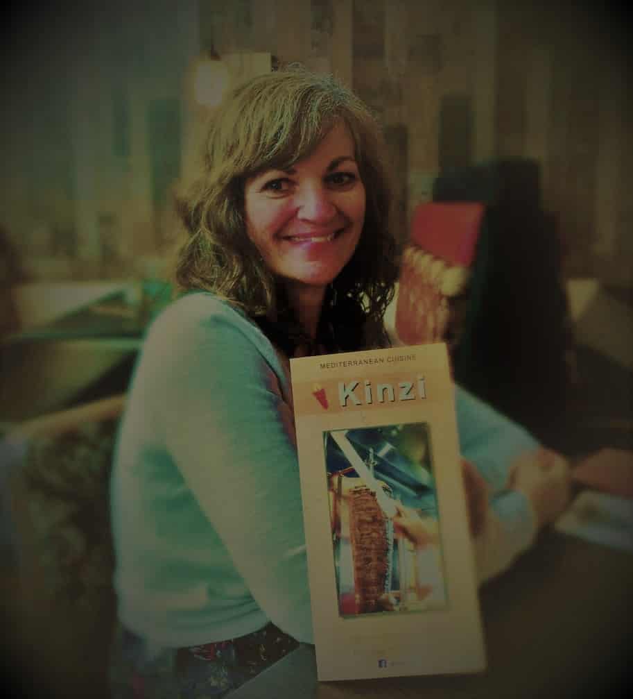 Crystal poses with a menu from Kinzi Restaurant in Mission, Kansas.