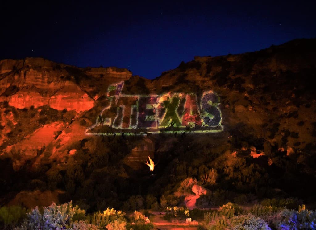 As the darkness grows, the Texas logo appears on the canyon wall.