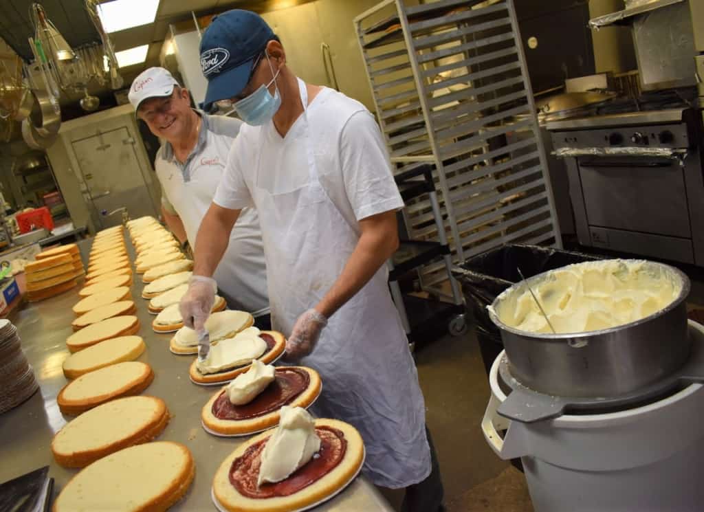Franco Cupini watches over a staff member who works at assembling some of the amazing desserts offered at Cupini's. 