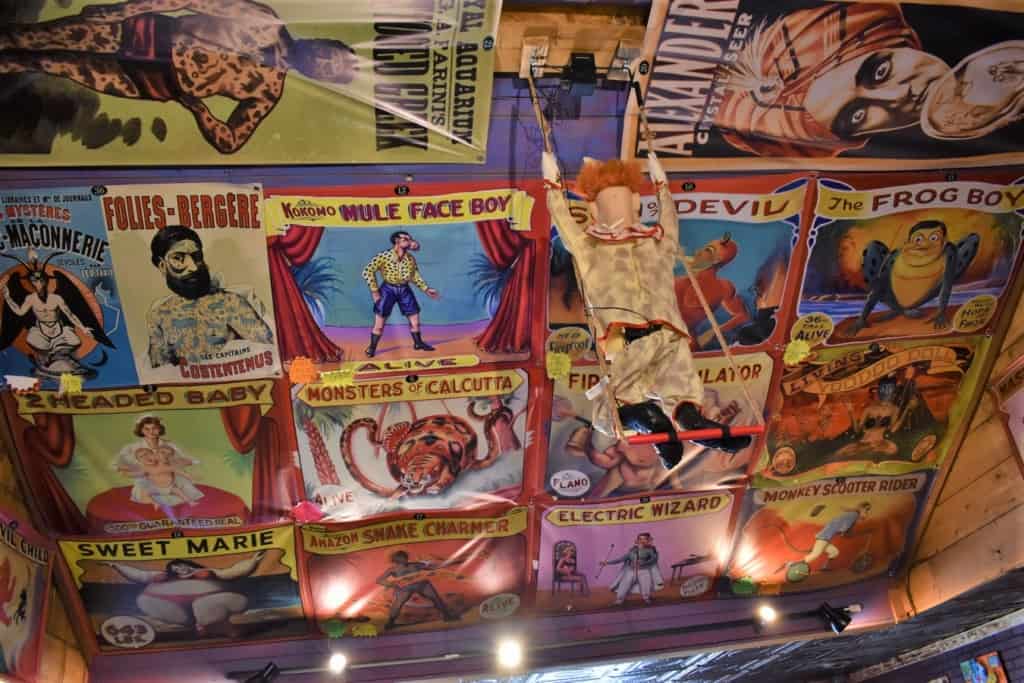 A celling covered with old advertisements for freak shows can be found inside the Uranus Sideshow Museum.