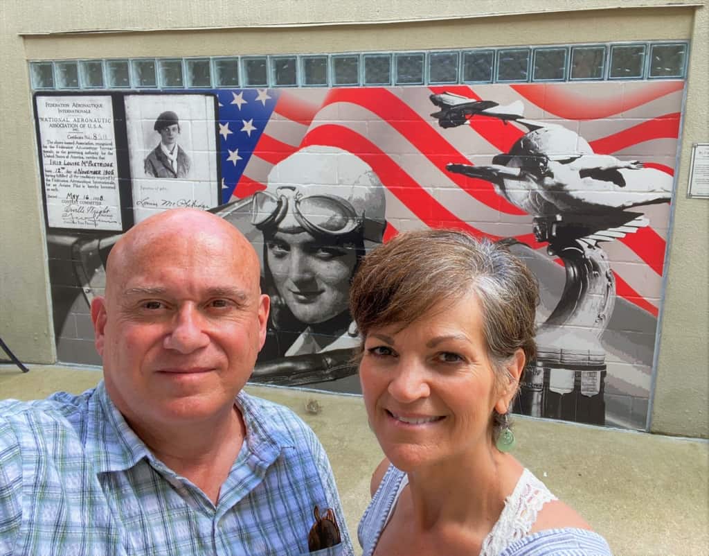 The authors pose in front of a local mural that touts the airborne inspiration brought by Louise Thaden. 