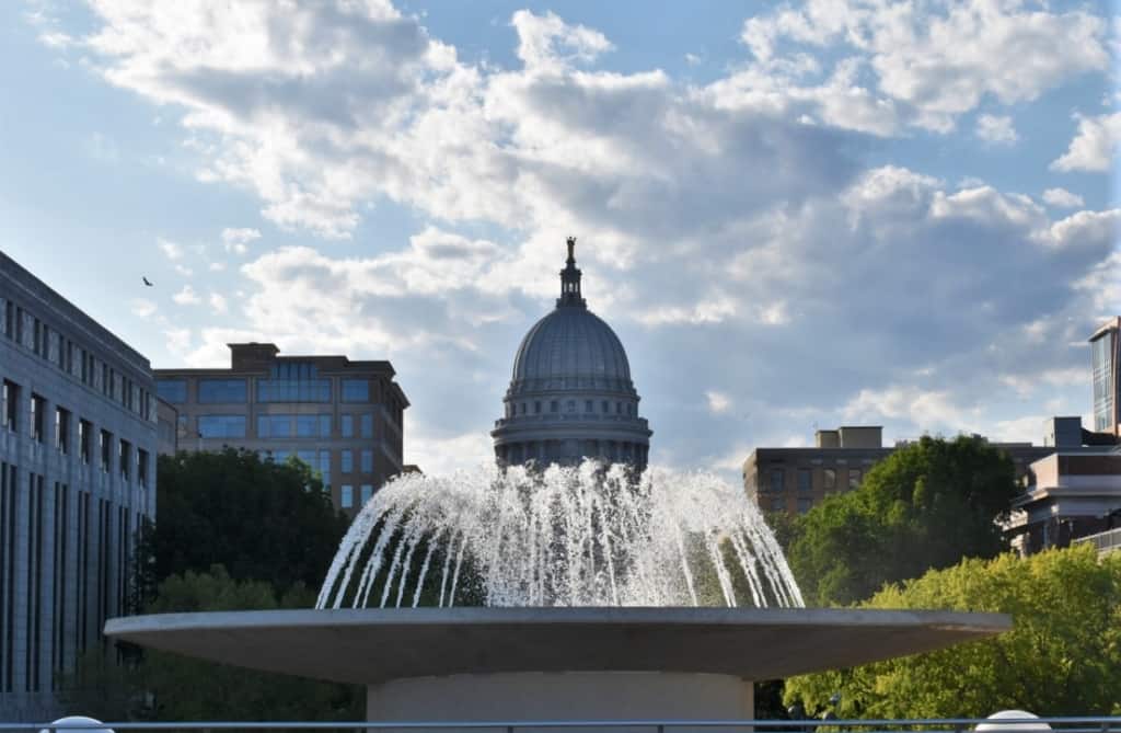 The Wisconsin capitol is framed by a fountain. 