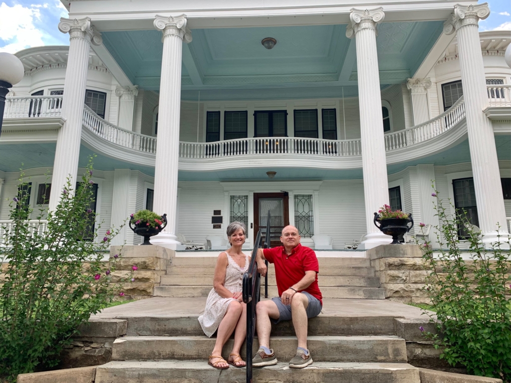 The authors pose for a selfie in front of the massive Seelye Mansion in Abilene, Kansas. 