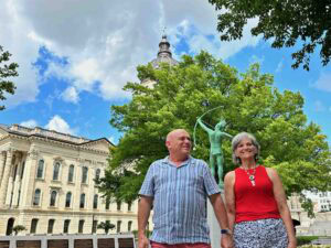 The authors pose on the grounds of the Kansas State Capitol.