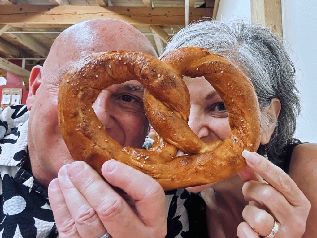 The authors peer through the holes of a gigantic pretzel during the visit to sample the tastes of Shipshewana.