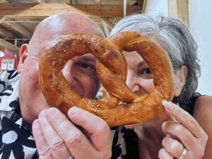 The authors peer through the holes of a gigantic pretzel during the visit to sample the tastes of Shipshewana.