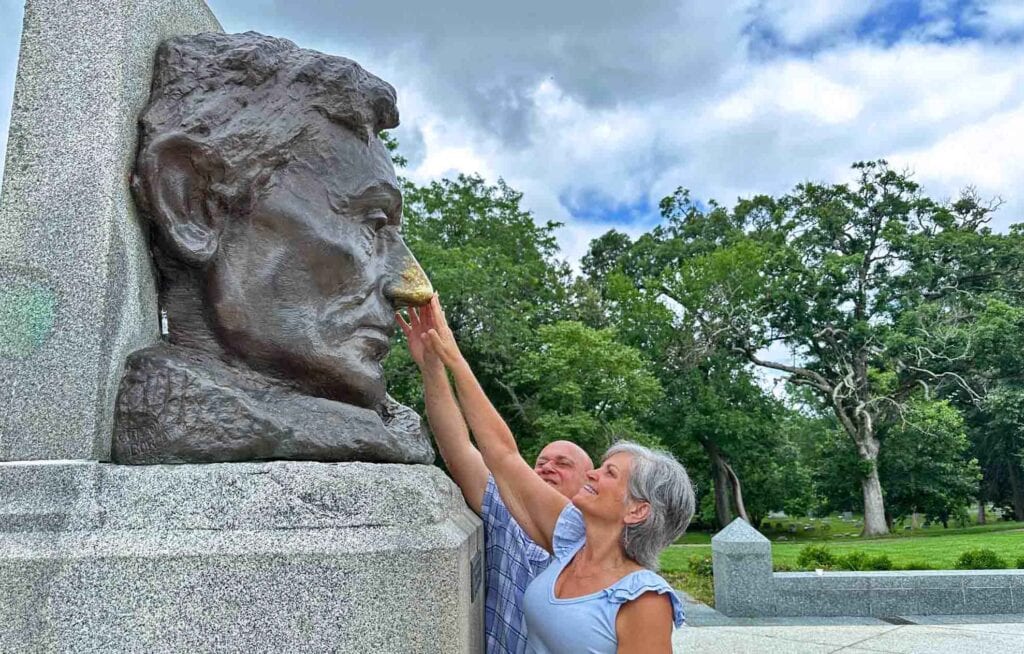 The authors are rubbing the nose of Lincoln's bust outside of his tomb.