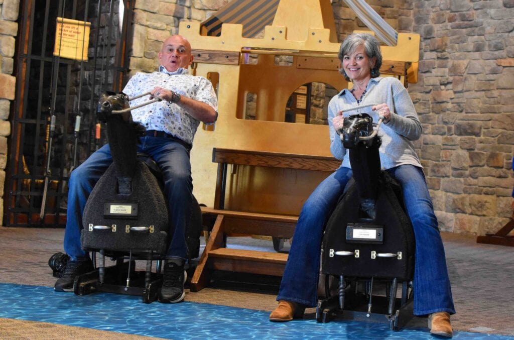 The authors enjoying their time at Exploration Place by riding pretend horses.