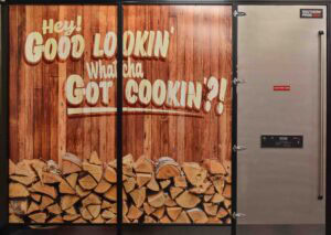 The entrance to the exhibits at the Museum of BBQ has visitors passing through a door borrowed from a smoker.
