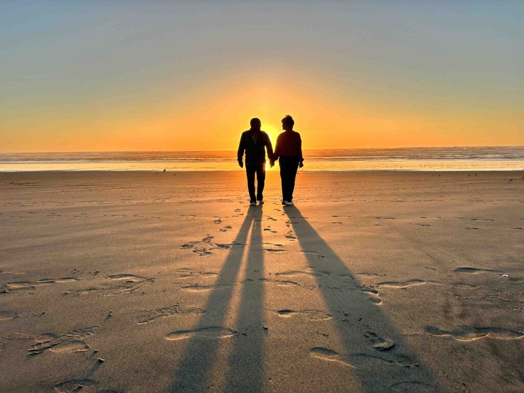 The authors take a sunset walk during their Oregon Coast road trip.