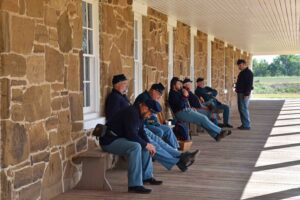 Reenactors in uniform pause in the shade during an event honoring Memorial Day.